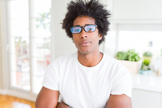 African American man wearing glasses Relaxed with serious expression on face. Simple and natural with crossed arms