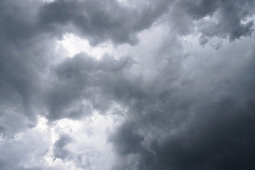 Dark, grim, stormy, rainy sky with rays of light. Scary hurricane clouds. Natural element. Stock Photo for your design