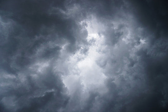 Dark, grim, stormy, rainy sky with rays of light. Scary hurricane clouds. Natural element. Stock Photo for your design