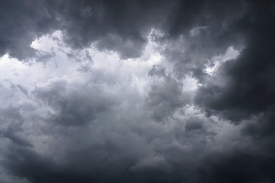 Dark, grim, stormy, rainy sky with rays of light. Scary hurricane clouds. Natural element. Stock Photo for your design