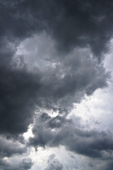 Fototapeta premium Dark, grim, stormy, rainy sky with rays of light. Scary hurricane clouds. Natural element. Stock Photo for your design