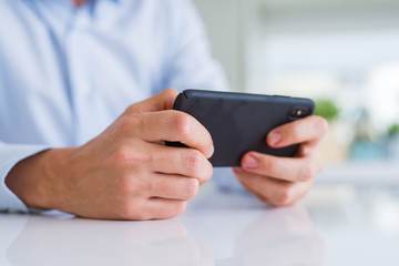 Close up of man hands using smartphone and smiling