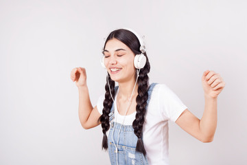Young girl portrait of listening music on gray background