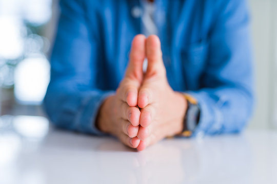 Close up of man hands with palms together over white table