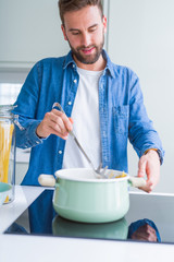 Handsome man cooking pasta at home