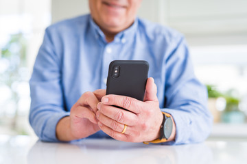 Close up of man hands using smartphone and smiling confident