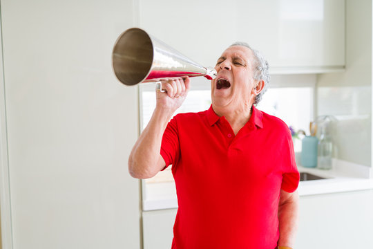 Senior man shouthing excited through vintage metal megaphone