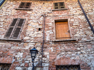 facade of shabby medieval brick house in Brescia