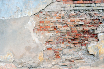 Old grungy red brick wall with peeled white beige stucco background. Vintage retro plaster wall...