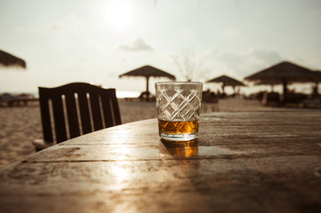 a whiskey glass on the beach 