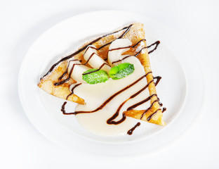 Thin delicious pancake with condensed milk on white