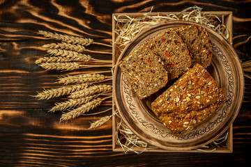 Home made organic goji berry Bread with seeds and ears wooden background close up. healthy food concept © Надія Коваль