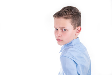 chic dressed boy in blue shirt looks critically over shoulder