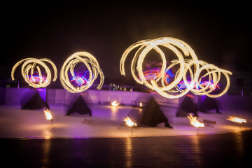 Amazing fire show dance. Fire dancers in beautiful costumes playing with colorful flames