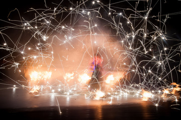 Amazing fire show dance. Fire dancers in beautiful costumes playing with colorful flames