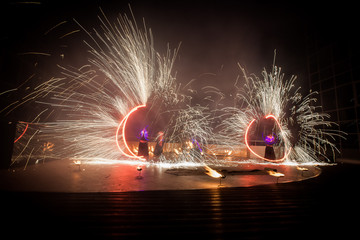 Amazing fire show dance. Fire dancers in beautiful costumes playing with flame