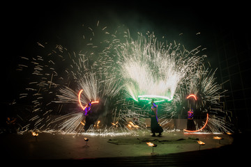Amazing fire show dance. Fire dancers in beautiful costumes playing with colorful flames