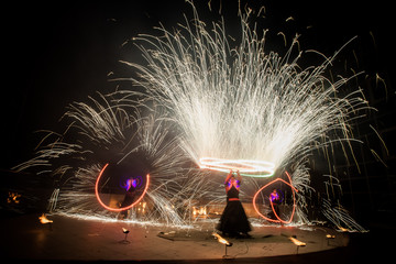 Amazing fire show dance. Fire dancers in beautiful costumes playing with colorful flames