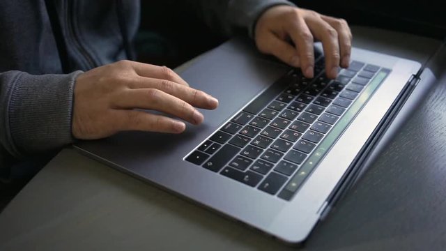 Digital technology, software development concept. Close-up hands - software developer (programmer) typing code for mobile device. Business office concept with cup of coffee and wooden table. Freelance
