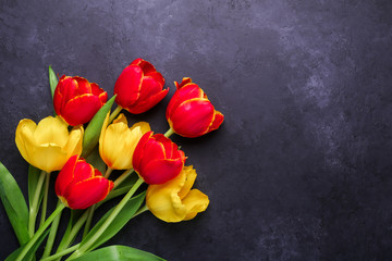 Fresh colorful tulips flowers bouquet on dark stone background