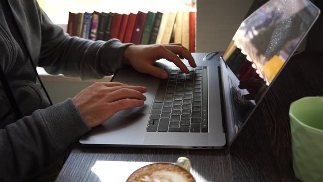 Digital technology, software development concept. Close-up hands - software developer (programmer) typing code for mobile device. Business office concept with cup of coffee and wooden table. Freelance