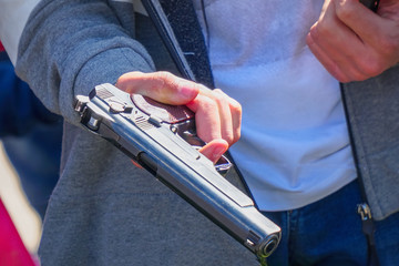 Gun in the hand of a man on a natural background