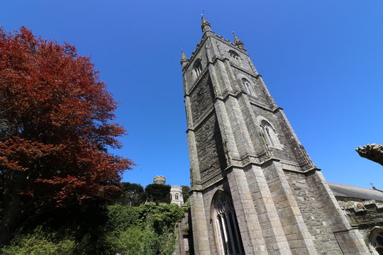 Spring in Fowey, United Kingdom. Red tree under the church tower.