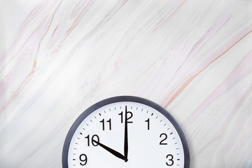 Wall clock show ten o'clock on white marble texture. Office clock show 10pm or 10am on marble...