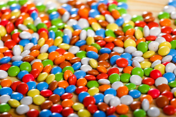 Fototapeta na wymiar colorful chocolate candies on wooden background