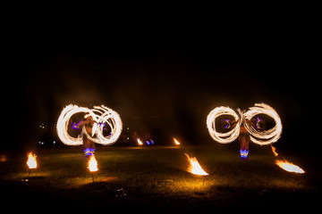 Amazing fire show dance. Fire dancers in beautiful costumes playing with colorful flames