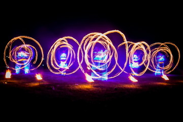 Amazing fire show dance. Fire dancers in beautiful costumes playing with colorful flames