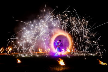 Amazing fire show dance. Fire dancers in beautiful costumes playing with colorful flames