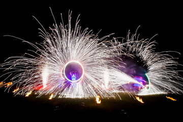 Amazing fire show dance. Fire dancers in beautiful costumes playing with colorful flames