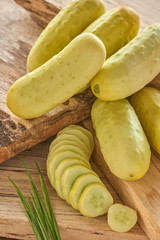 white heirloom cucumber with slices on barn board