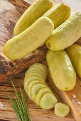 white heirloom cucumber with slices on barn board with dew
