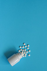 Assorted pharmaceutical medicine pills, tablets and capsules and bottle on blue background. Drugs and various narcotic substances. Copy space for text. Stock photo for design