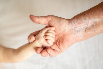 hands of young great-grandson and old great-grandmother. Happy Family concept. Beautiful conceptual image of Maternity. selective focus