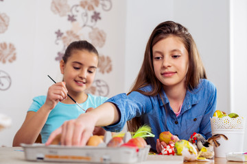 Photo of cute kids painting Easter eggs at home