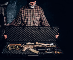 Illegal sale of weapons, black market, the criminal opens the case with an assault rifle and shows...