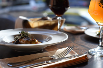 Lunch at the restaurant. Served wooden table. Meat dish. Light and dark beer in glasses. Nobody