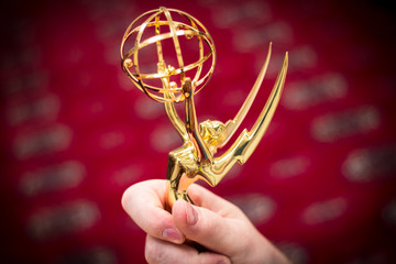 Closeup view of a hand holding an Emmy Award.