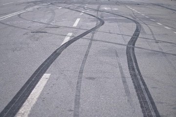 Abstract of Black tire wheels caused by Drift car on the road. Braking at a pedestrian crossing and a road with markings. Stock photo for design