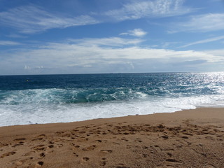 Strand, tiefblaues Meer, Himmel und Wolken in Tossa de Mar / Spanien