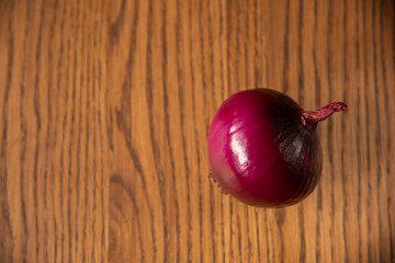 Fresh purple onion on dark wooden background.