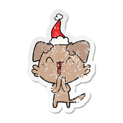 laughing little dog distressed sticker cartoon of a wearing santa hat