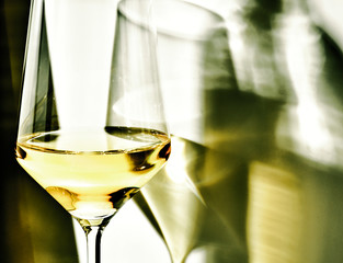 Blurred reflections of wine glass on white wall