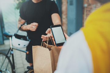 Courier delivery food service at home.Man courier delivered the order no name bag with food.Woman checking the order with mobile phone