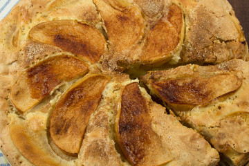 Close-up of apple pie with large slices of apples and a sliced piece