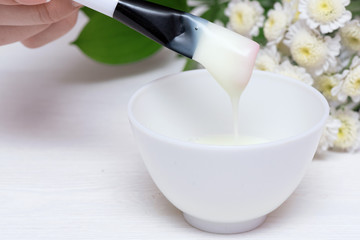 Natural cosmetic face mask in a jar on a white table background.