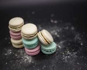 colored macaroons on a black background